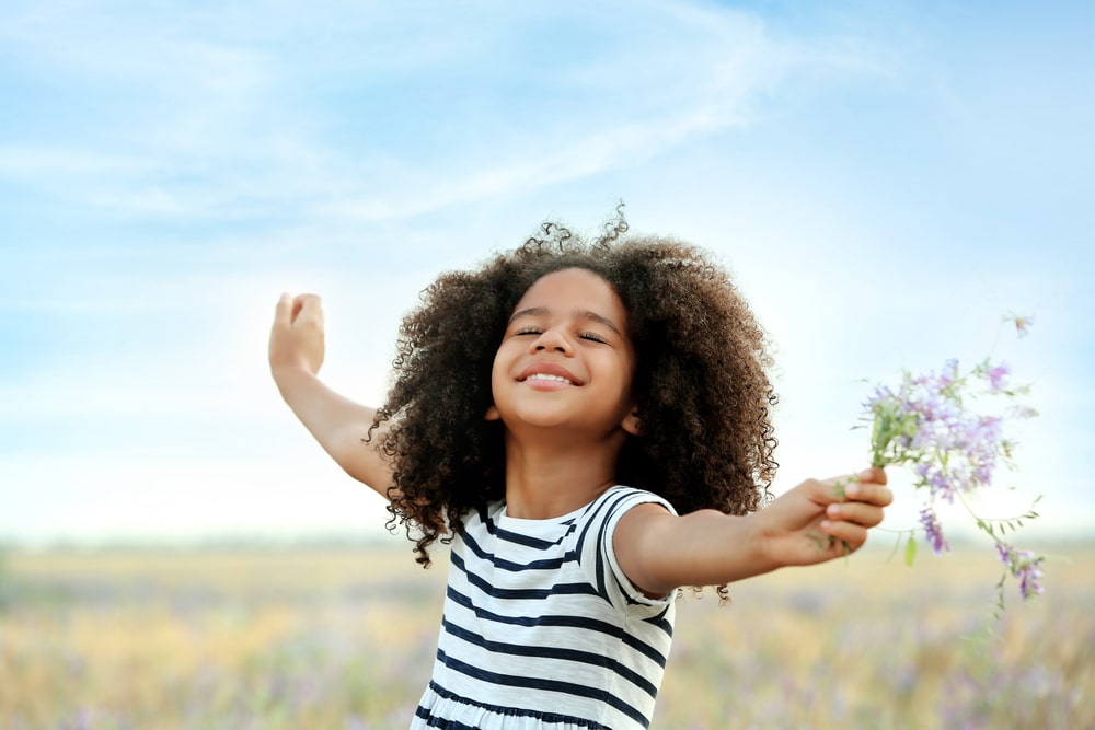 Happy little African American girl in the field